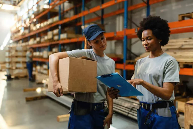 african-american-worker-her-coworker-reading-order-list-before-shipment-while-working-warehouse_50